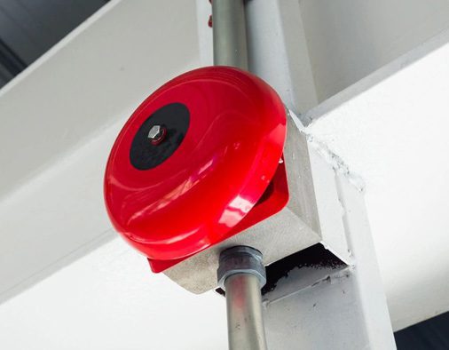 A red fire alarm on the side of a building.