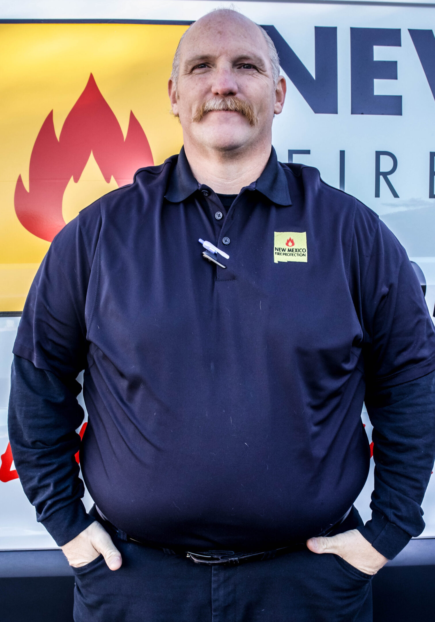 A man standing in front of a fire station.